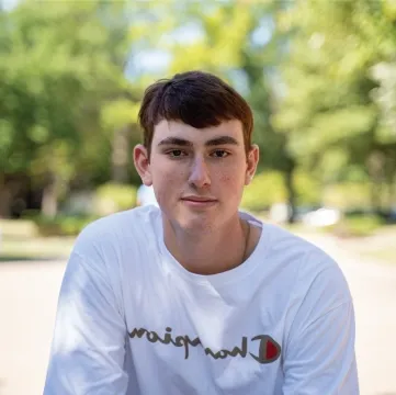 Student outdoors looking directly at camera.